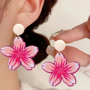 Detailed close-up of pink cherry blossom dangle earrings featuring white pearl studs