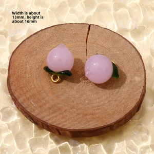 Macro detail of a 13mm pink peach glass pendant with gold ring on a wooden texture