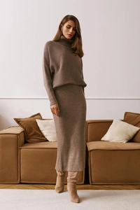 Detailed texture of brown ribbed knit turtleneck sweater and long skirt on a model