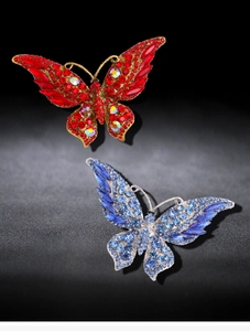 Detailed close-up of crystal butterfly brooches with red and blue gemstone inlay