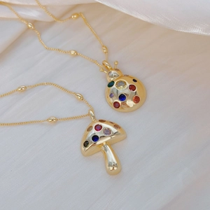 Gold-plated mushroom and beetle pendant necklaces with colorful gemstones on silk