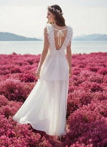 Details der Rüschenträger und des rückenfreien Designs am weißen langen Strandkleid