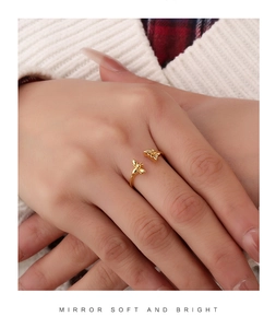 Close-up of golden adjustable open ring featuring delicate bee and insect charms on hand