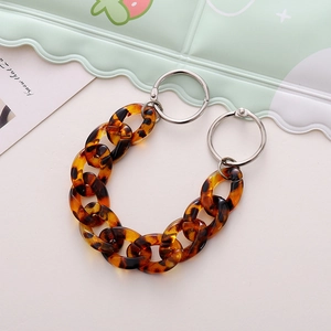 Close-up of amber acrylic chain accessory with silver rings for hole shoes and bags