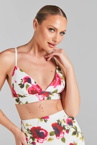 Détail du crop top à imprimé rose avec fines bretelles et motifs floraux