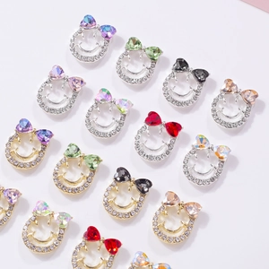 Bowtie and smiley face nail charms with colorful rhinestones in gold and silver settings