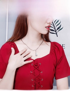 Gros plan d'un collier avec pendentif queue de poisson argenté porté par un mannequin