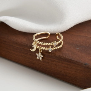 Macro shot of S925 sterling silver gold ring with star and moon charms and zircons