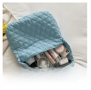 Macro view of spacious interior of light blue quilted tote bag showing large capacity