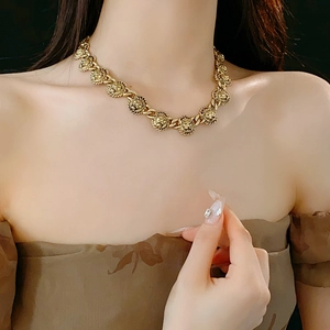 Détail du collier tête de lion vintage doré sur mannequin avec fond sombre