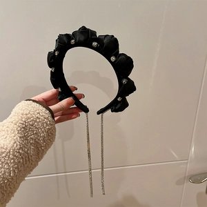 Detail of black satin floral headband with sparkling rhinestone tassel chains