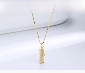 Detail view of gold-plated bamboo pendant featuring creamy opal stone and fine crystals