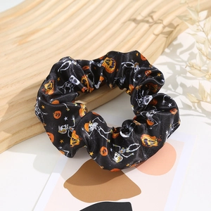 Detail of Halloween scrunchie with pumpkin and skull prints on silk-like fabric