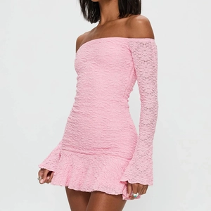 Detail of pink lace off-the-shoulder dress with elegant flared sleeves and floral pattern