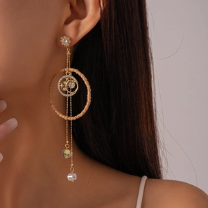 Detail of long fringe drop earring featuring woven ring and star moon charms on a model