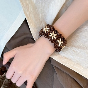 Close-up of a handmade vintage ethnic style wooden bead bracelet on a woman's wrist