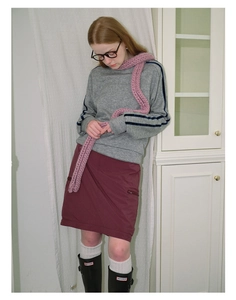 Pink chunky knit long scarf styled with a grey sweatshirt and tall black rain boots