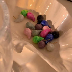 Colorful marble textured teardrop enamel stud earrings in a white shell display dish