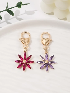 Detail of floral bag charms in rose and purple with heart-engraved lobster clasps