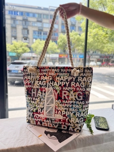 Detail of canvas bag with braided rope handle and red black floral pattern print
