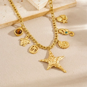 Gold sea star and shell pendant necklace with ocean charms on travertine stone