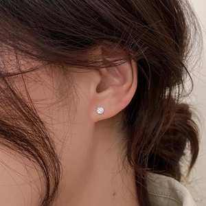 Gros plan d'une boucle d'oreille en argent s925 avec une pierre de zircone ronde brillante