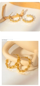 Macro shot of gold daisy flower hoop earrings featuring vintage floral pattern detail