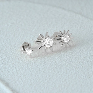Macro detail of three silver S925 starburst earrings with sparkling zircon stones