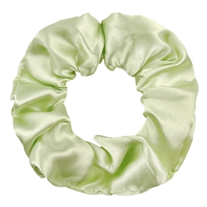 Close-up of light green satin hair scrunchie showing smooth fabric texture and elastic pleats