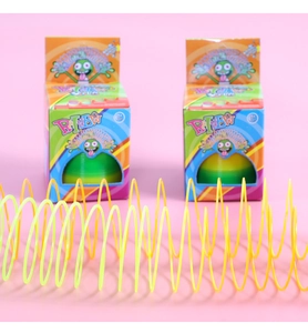 Close-up of yellow rainbow spring toy with cartoon monster packaging on pink background