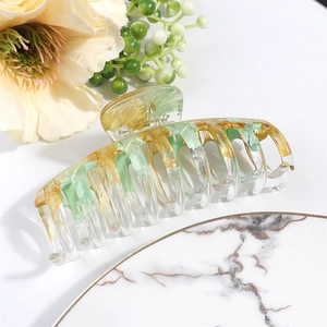Detailansicht der großen Haarspange mit grün-goldener Marmorierung auf Marmorteller