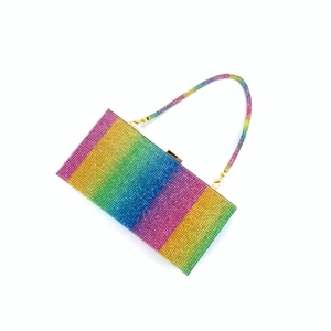 Macro shot of sparkling rainbow rhinestone evening clutch with elegant gold chain strap