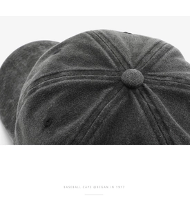 Close-up of grey corduroy baseball cap showing textured fabric and stitched eyelets
