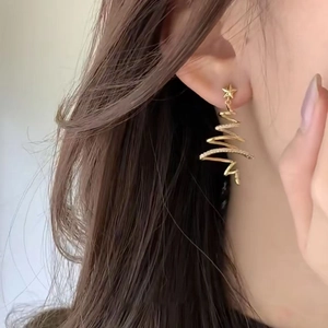 Gold plated star Christmas tree earrings with zircon details on female model