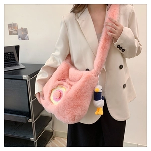 Close-up of pink plush crossbody bag featuring a cute duck pendant and donut embroidery