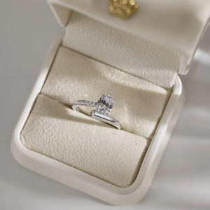 Macro detail of oval zircon silver ring nestled in a premium beige velvet jewelry box