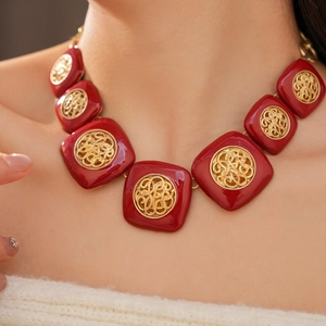 Dettaglio di una collana vintage in smalto rosso con centri in filigrana d'oro