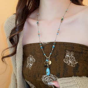 Dettaglio della collana boho con perline colorate e ciondolo in finta turchese