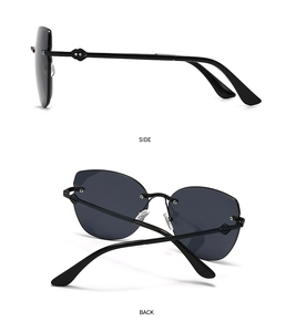 Detail view of modern retro cat-eye sunglasses with golden metal temples and gray lenses