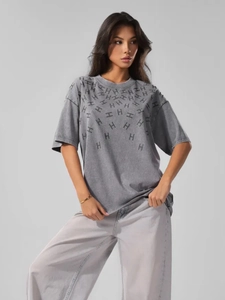 Close-up of vintage washed cotton tee with rhinestones and distressed graphic detail