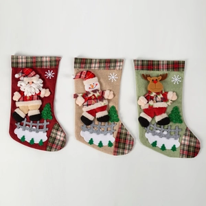 Trois chaussettes de Noël avec Père Noël, bonhomme de neige et renne en 3D et carreaux