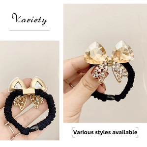 Detail of crystal bow hair tie with champagne stones and black elastic band