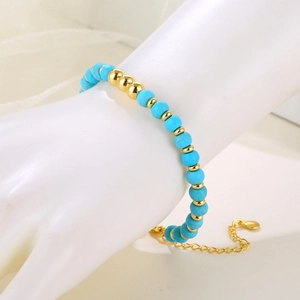 Detail of beaded bracelet with turquoise blue beads and adjustable gold lobster clasp