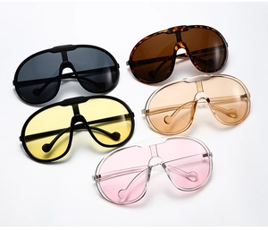 Flat lay of trendy oversized shield sunglasses in black, tortoiseshell, yellow, and tea colors