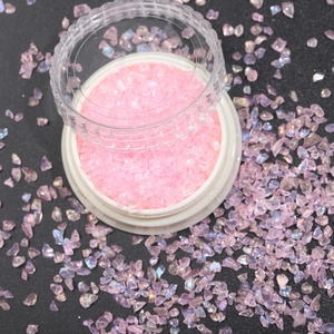 Macro shot of colorful iridescent nail art glass shards in a pink and purple gradient