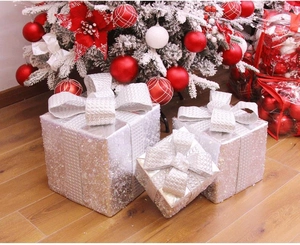 Set di tre scatole regalo di Natale argentate con paillettes su parquet chiaro