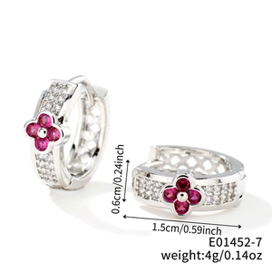 Detail view of silver clover huggie earrings with pink zircons and 1.5cm outer diameter
