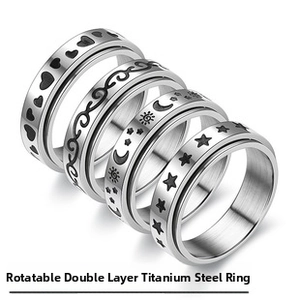 Detail showing five titanium steel rings with rotating bands and engraved motifs