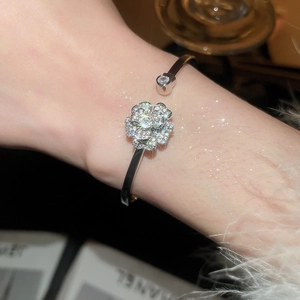 Dettaglio dell'elegante bracciale a polsino con fiori in argento e zirconi pavé