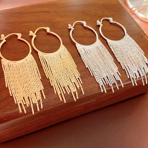 Chic gold and silver tassel hoop earrings displayed on a professional jewelry stand